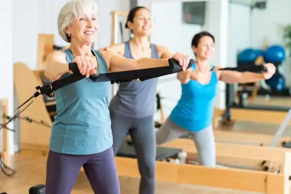 Toning Arms After 60: Empowering Womens Fitness Through Effective Weight Training 2 older woman doing weight training Rotherham and resistance in the gym to tone upper arms