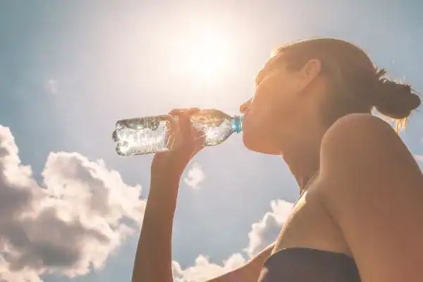 Hydration: The Secret Ingredient for a Toned Stomach and Enhanced Fitness 3 Image of woman drinking water to hydrate Rotherham after run.