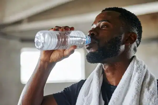 Hydration: The Secret Ingredient for a Toned Stomach and Enhanced Fitness 1 Image of man drinking water to improve hydration Rotherham after work out.